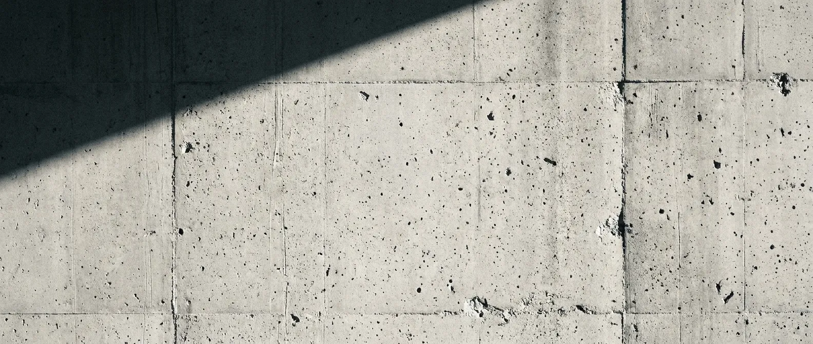 Rohe Betonwand mit hartem Schattenwurf